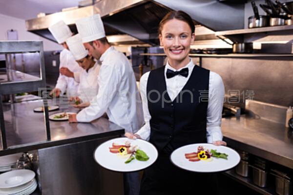 數(shù)據(jù)捕捉的新視角 服務(wù)員向相機(jī)展示盤子的數(shù)據(jù)庫管理意義